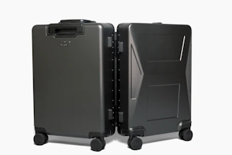 A stylish carry-on suitcase with built-in organizer compartments, standing next to a travel backpack.