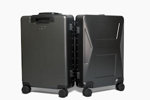 A stylish large suitcase in matte black with a spacious interior and wet/dry separation compartments open to show organization.