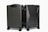 Two sleek, black hard-shell suitcases positioned side by side on four wheels each, showcasing modern design and durability with a smooth matte finish.