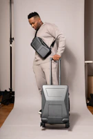 A model wearing a matching set of soft gray sweatpants and sweatshirt against a minimalist urban backdrop.