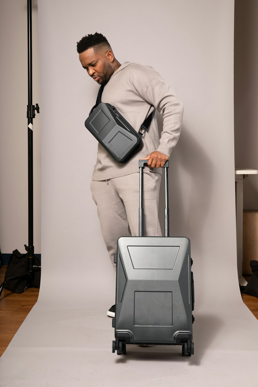 a man is holding a suit case and a bag
