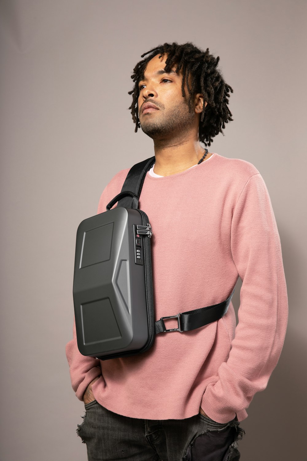 a man with dreadlocks holding a black bag