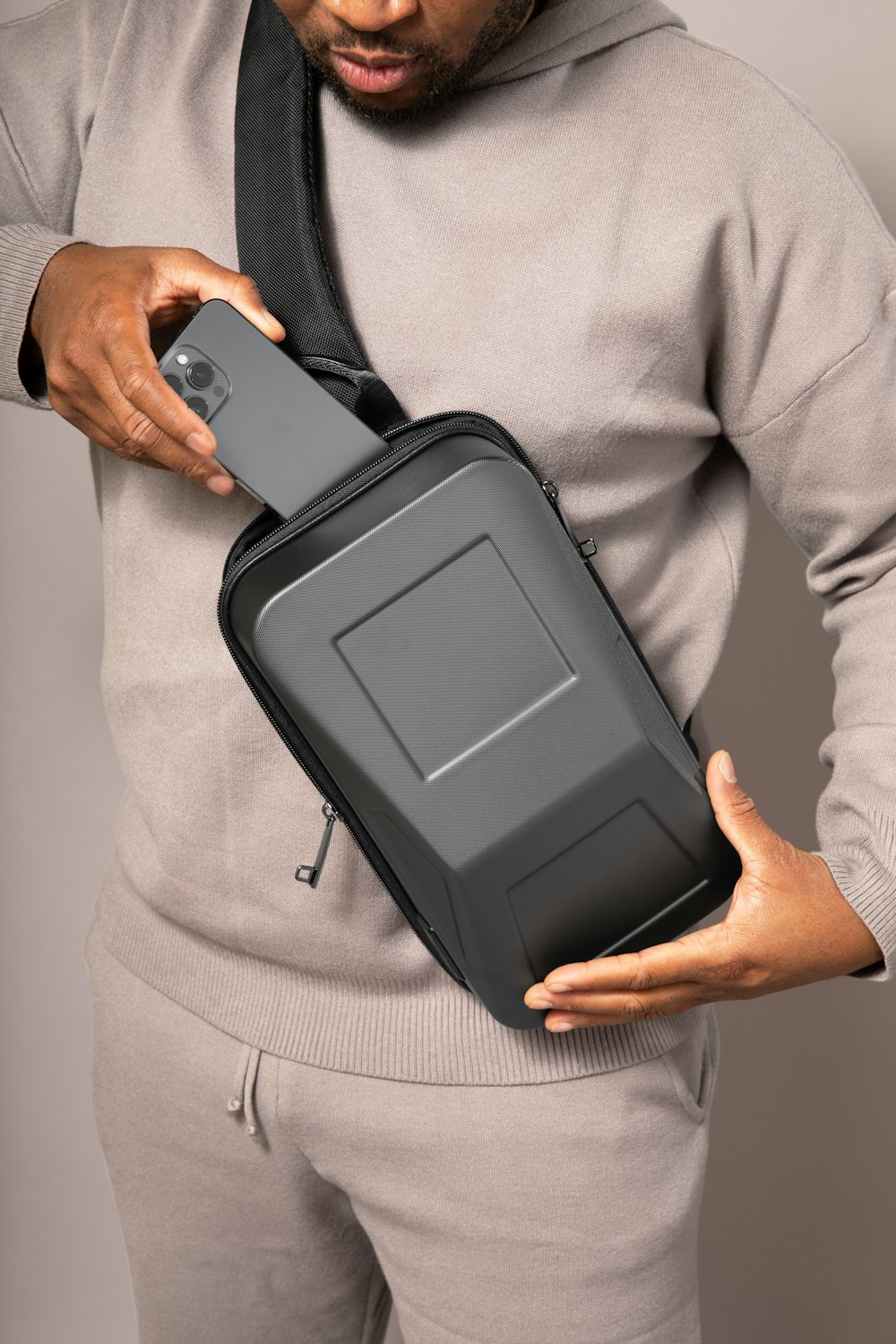 a man is holding a case with a cell phone in it