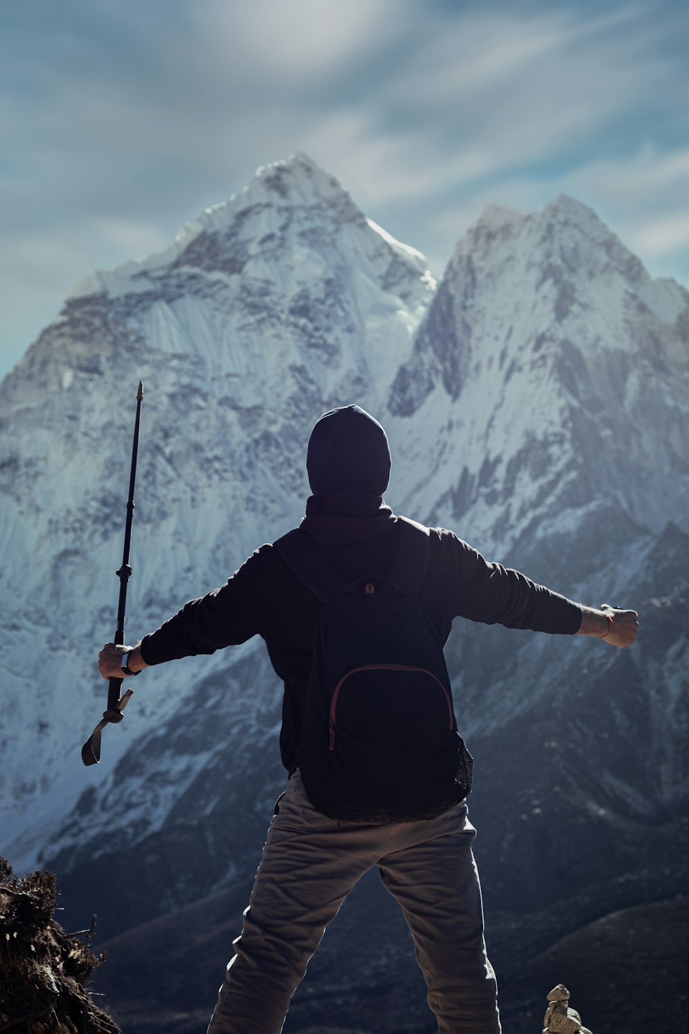 Un hombre sosteniendo un rifle mientras está parado en la cima de una montaña