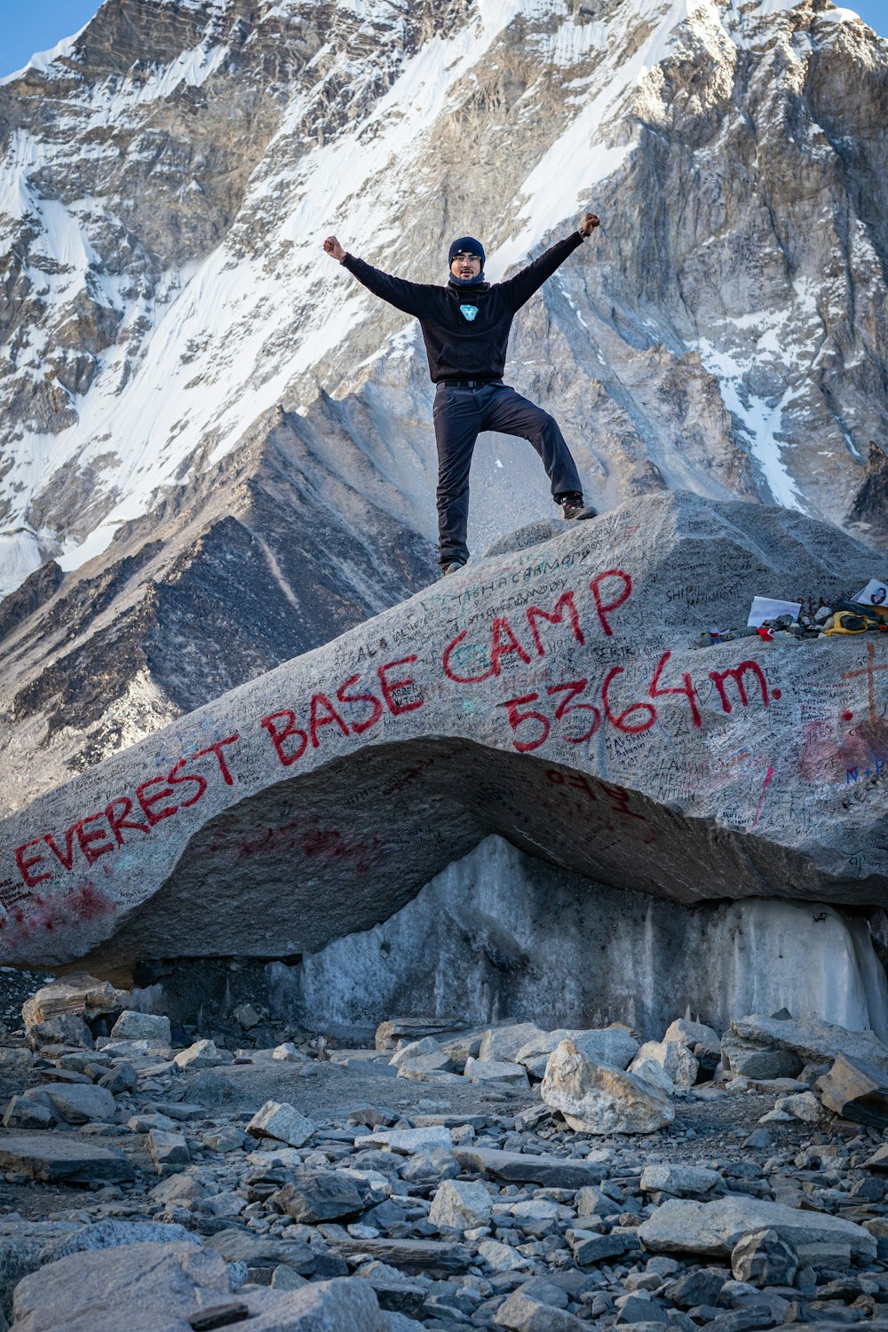 a man standing on top of a large rock