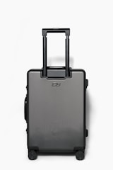 A sleek, modern black suitcase with four wheels and a retractable handle is positioned against a plain white background. The suitcase has a minimalist design with a logo on the front.