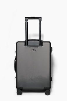 A sleek black suitcase covered with a bold, personalized mimaleta cover featuring a vibrant geometric pattern.