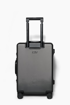 A sleek, durable carry-on suitcase with rajiree branding, set against a backdrop of a luxury hotel lobby.