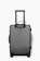 Close-up of a sleek black Travora suitcase with gold accents on a polished airport floor.