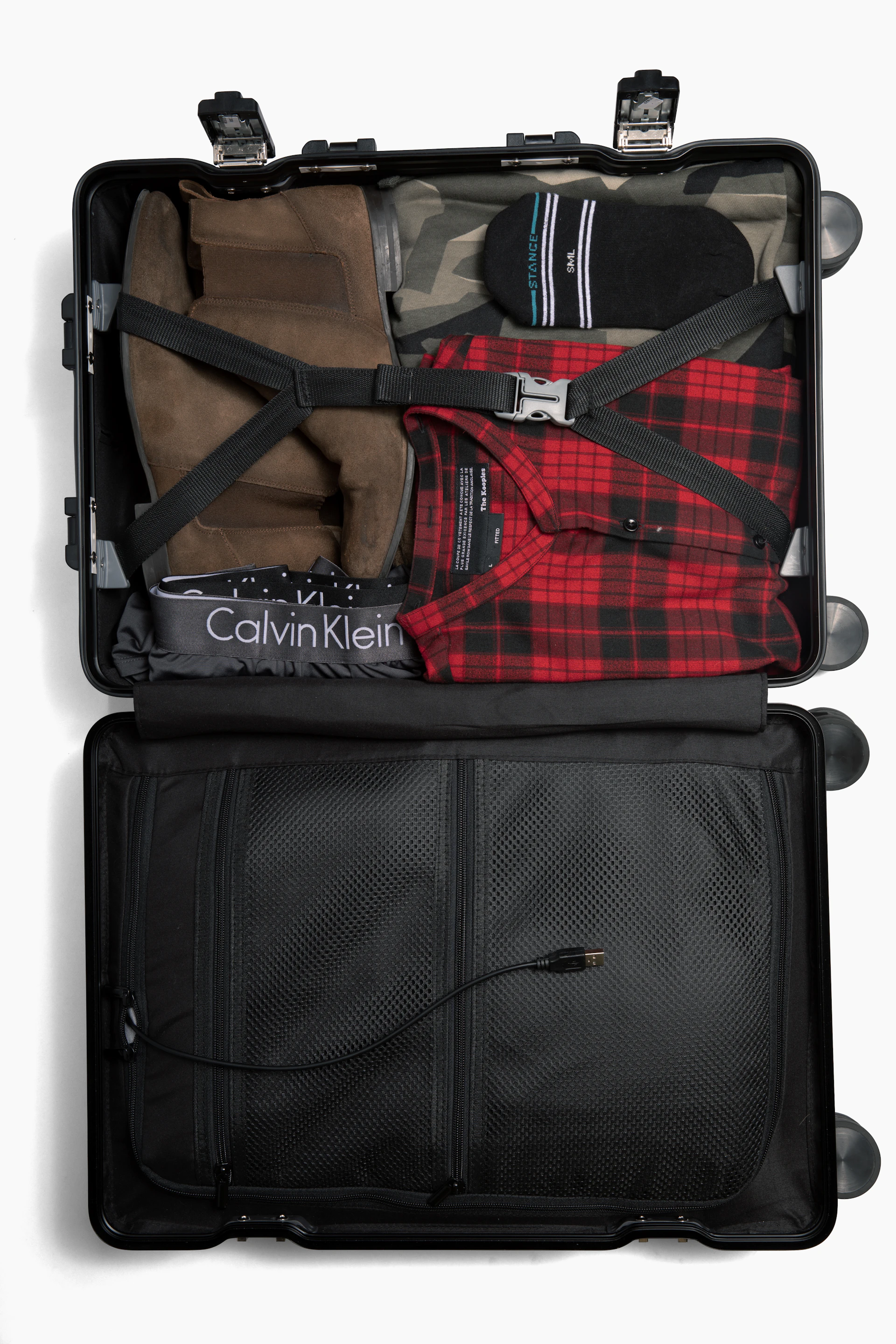 Open travel suitcase packed with clothes