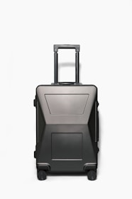 A sleek carry-on bag standing upright on a wooden floor, showcasing its scratch-resistant fabric and reinforced corners.