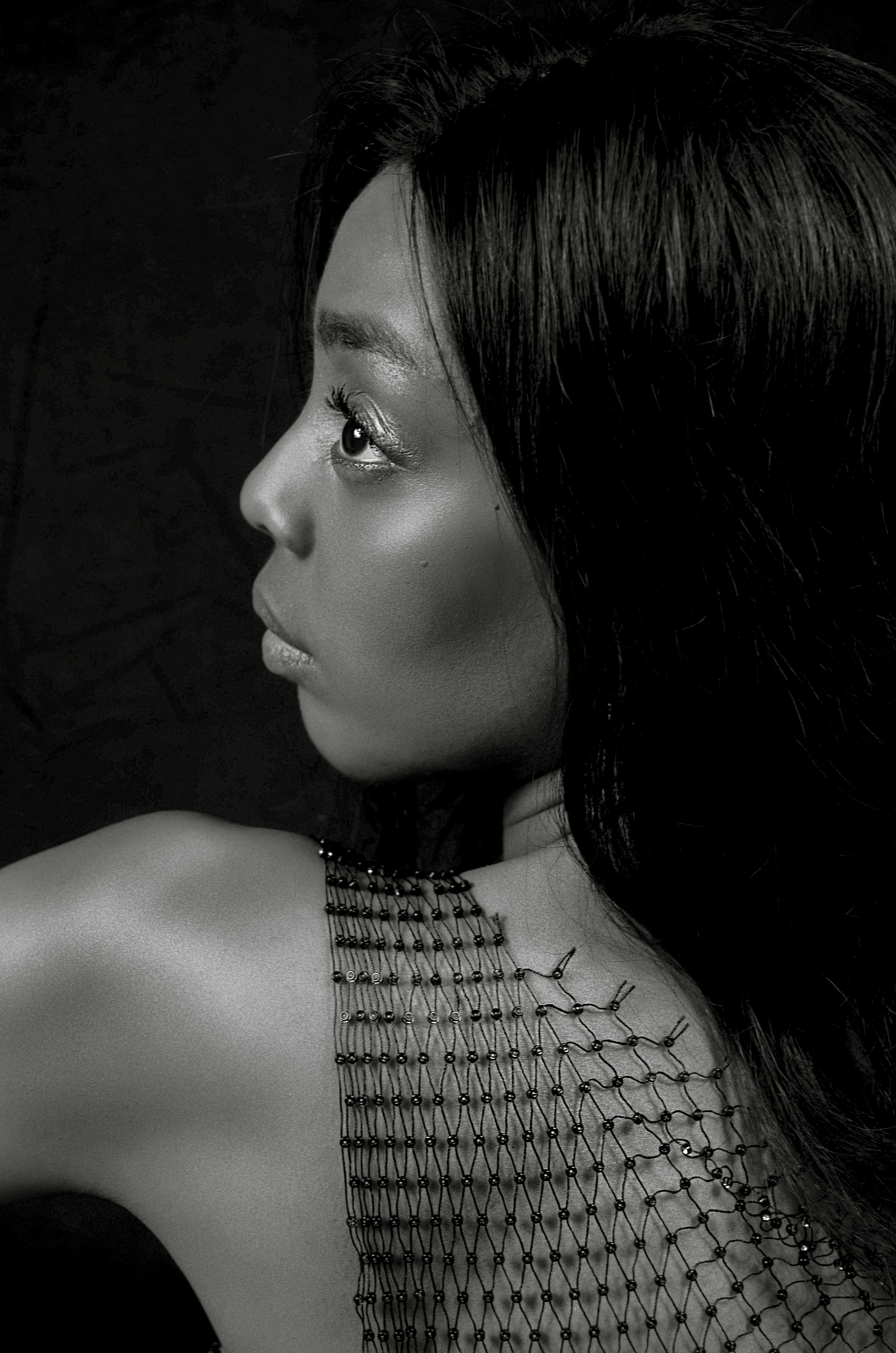 a woman in a fishnet top looking off into the distance