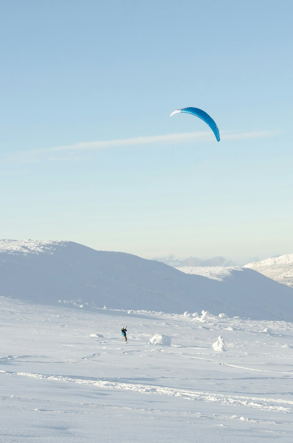 a person is flying a kite in the snow