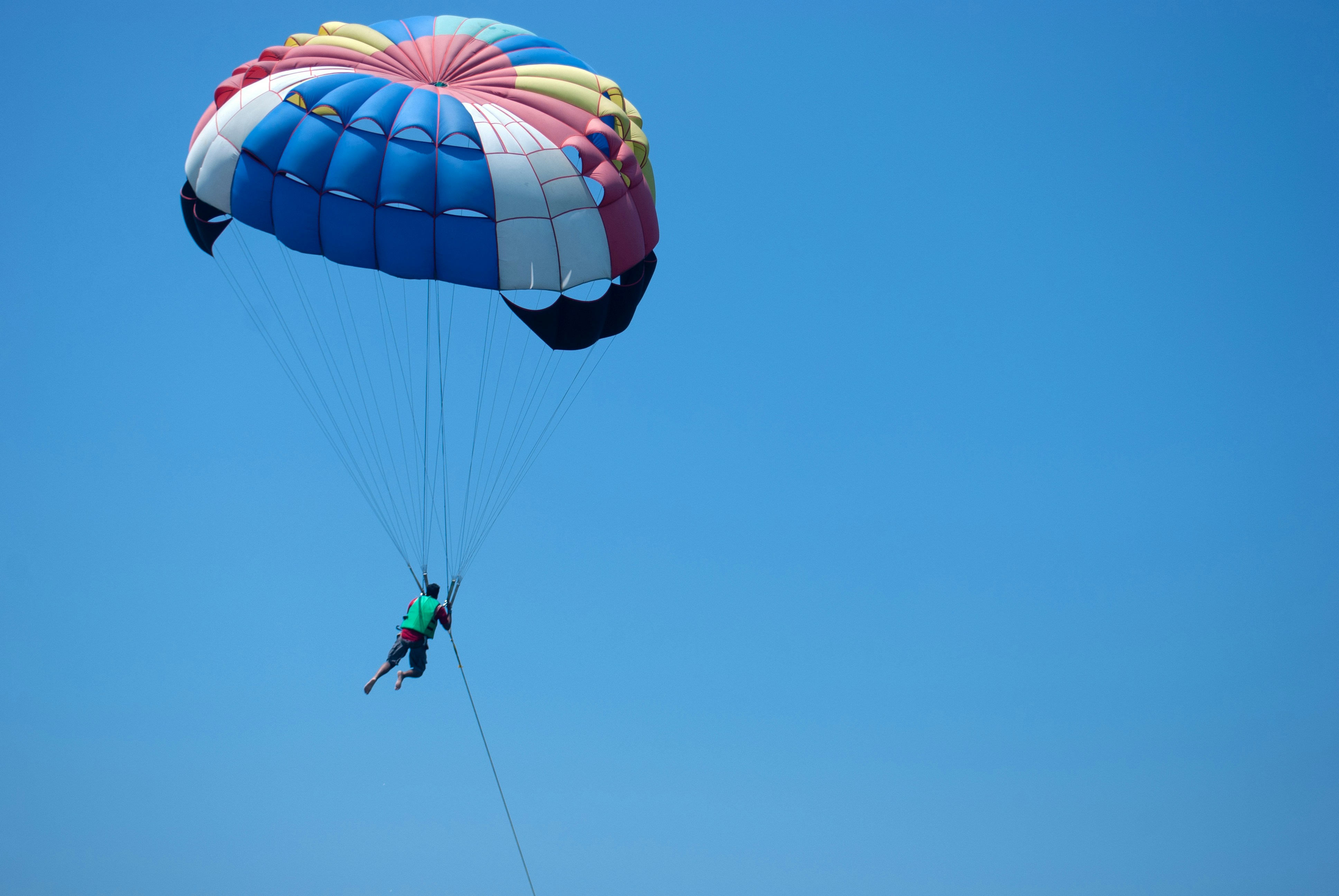 a person is parasailing high in the sky, Parasailing in Pattaya, Thailand. On the way to Coral Island from Pattaya beach.