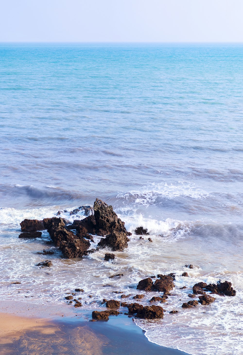 Una spiaggia rocciosa con uno specchio d'acqua sullo sfondo