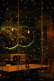 A warmly lit room set up for an intimate private party with string lights and rustic decor.