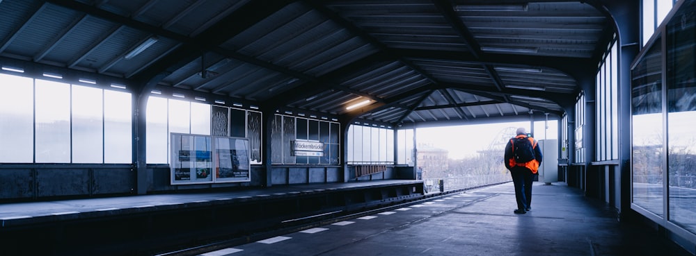 a man walking down a train station platform