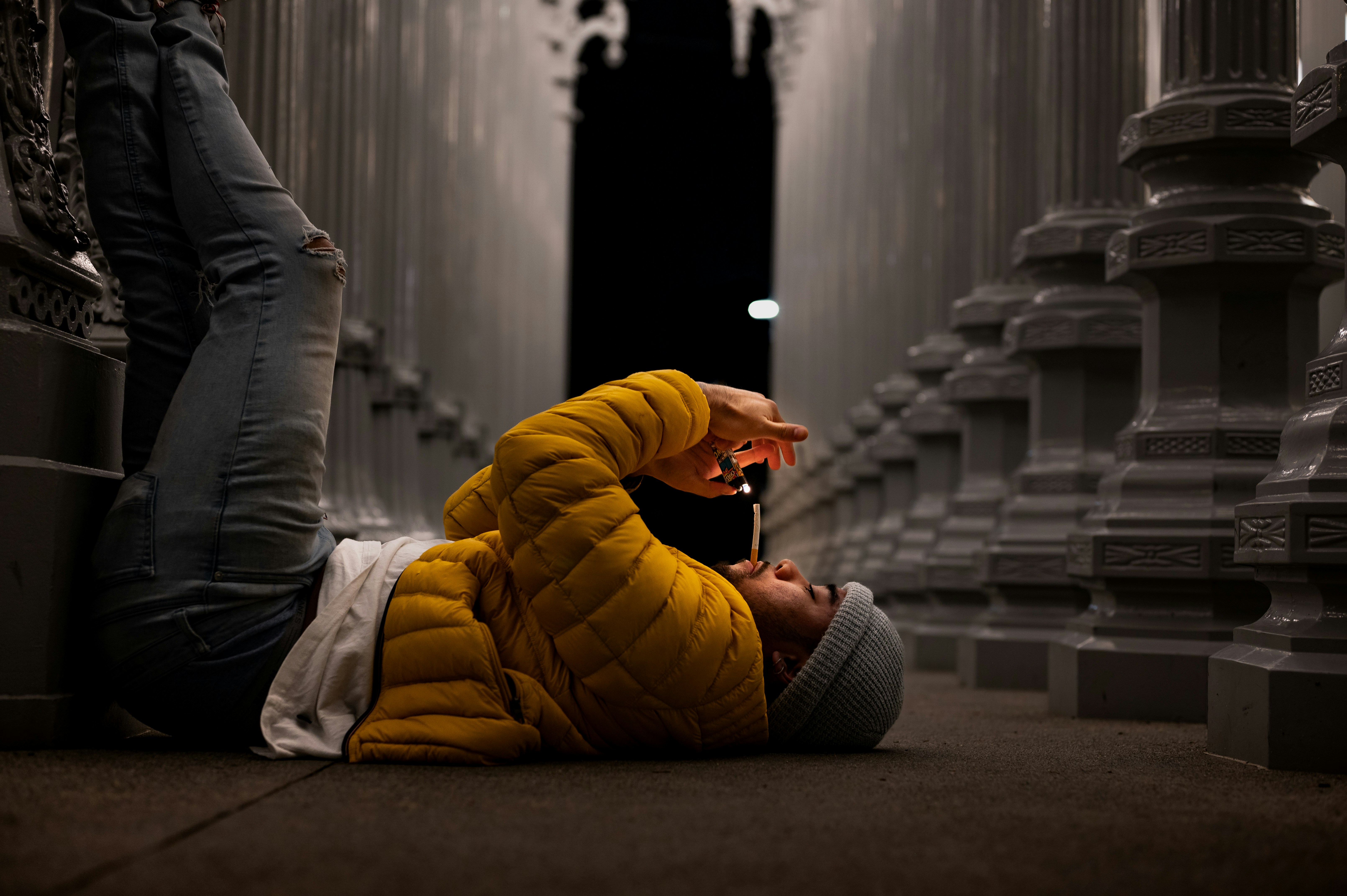 a person laying on the ground with a cell phone in their hand