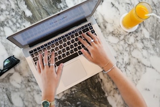 a woman using a laptop computer on a marble table