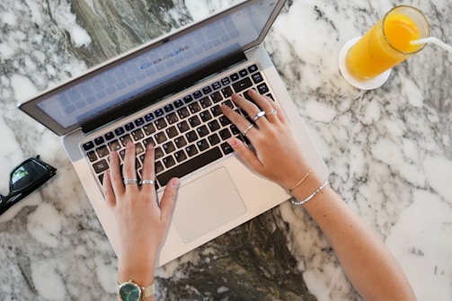 a woman using a laptop computer on a marble table