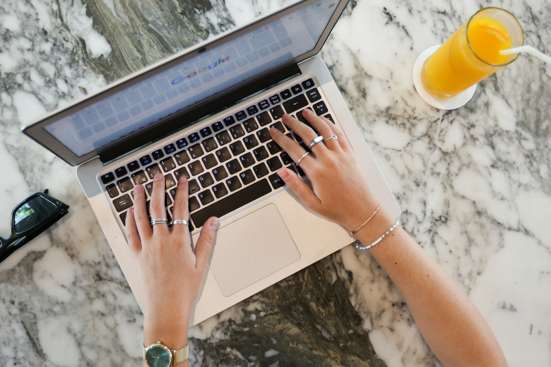 a woman using a laptop computer on a marble table