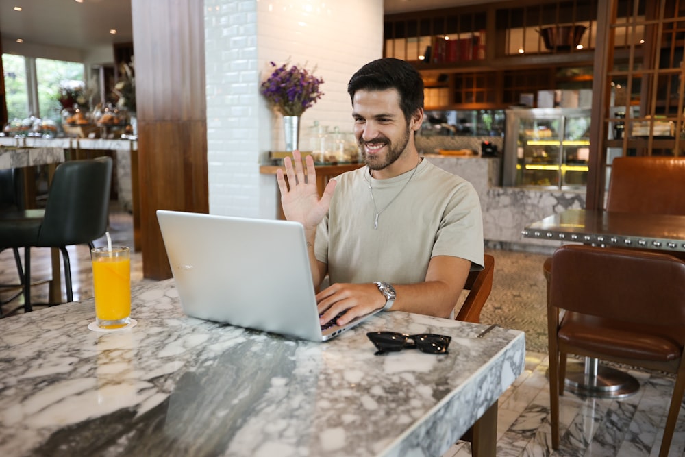 a man sitting at a table using a laptop computer