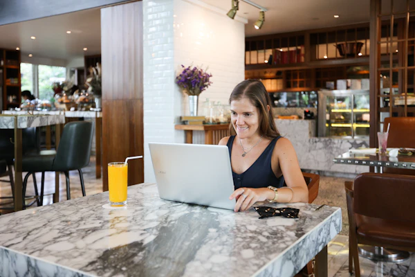 Restaurant owner writing a business plan at a desk with laptop and notes