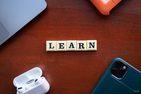 the word learn spelled with scrabble letters on a wooden table