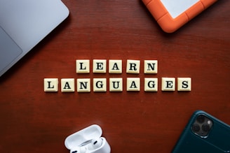 a wooden table topped with scrabble tiles spelling learn languages