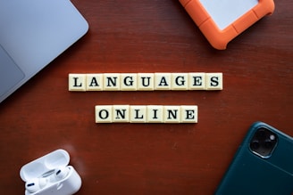 a wooden table topped with scrabble tiles that spell out languages
