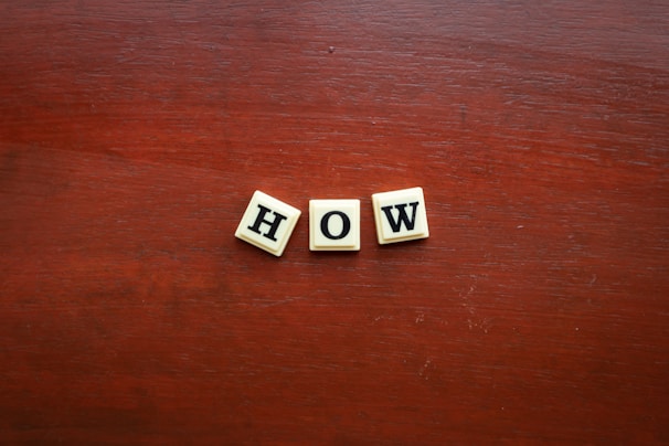 the word wow spelled with scrabble letters on a wooden surface