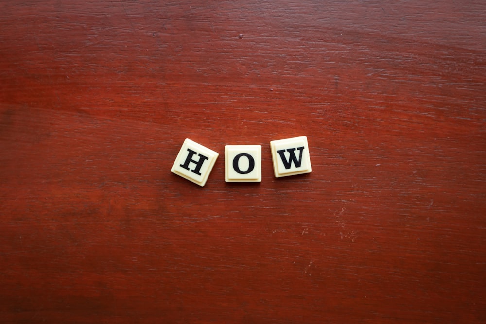 the word wow spelled with scrabble letters on a wooden surface