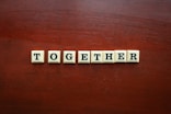 the word together spelled with scrabble tiles on a wooden surface