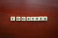 the word together spelled with scrabble tiles on a wooden surface