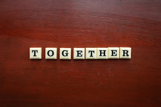 the word together spelled with scrabble tiles on a wooden surface