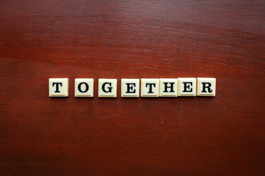 the word together spelled with scrabble tiles on a wooden surface