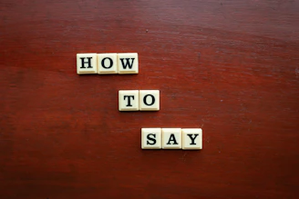 scrabble tiles spelling how to say on a wooden surface