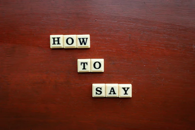 scrabble tiles spelling how to say on a wooden surface