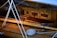 An interior of a wooden boat featuring polished wooden surfaces and multiple ropes coiled neatly. The cabin walls have a warm, honey-colored finish with a few rectangular panels. Slight reflections hint at a glossy sheen on the wood.