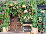 Elegant historic hotel entrance framed by blooming flowers and lanterns.