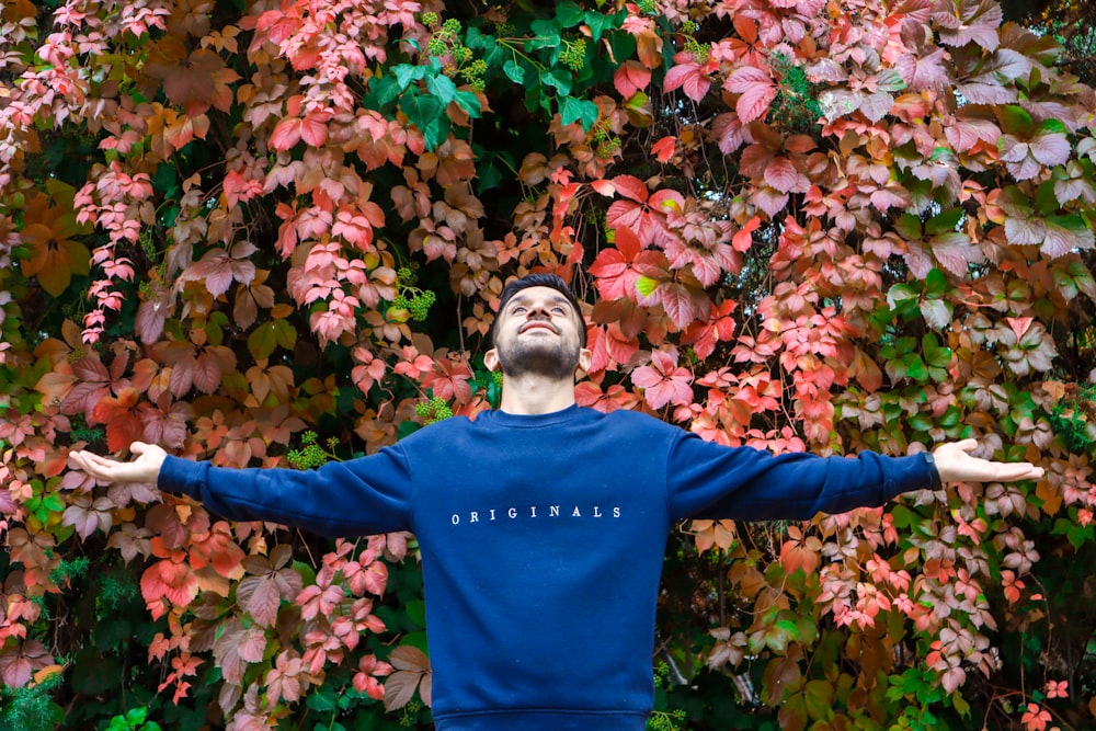 a man standing in front of a colorful tree