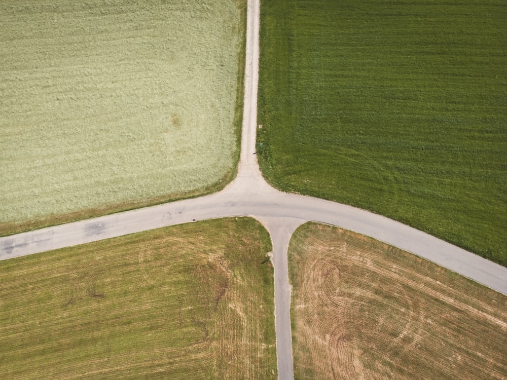 an aerial view of a road in the middle of a field