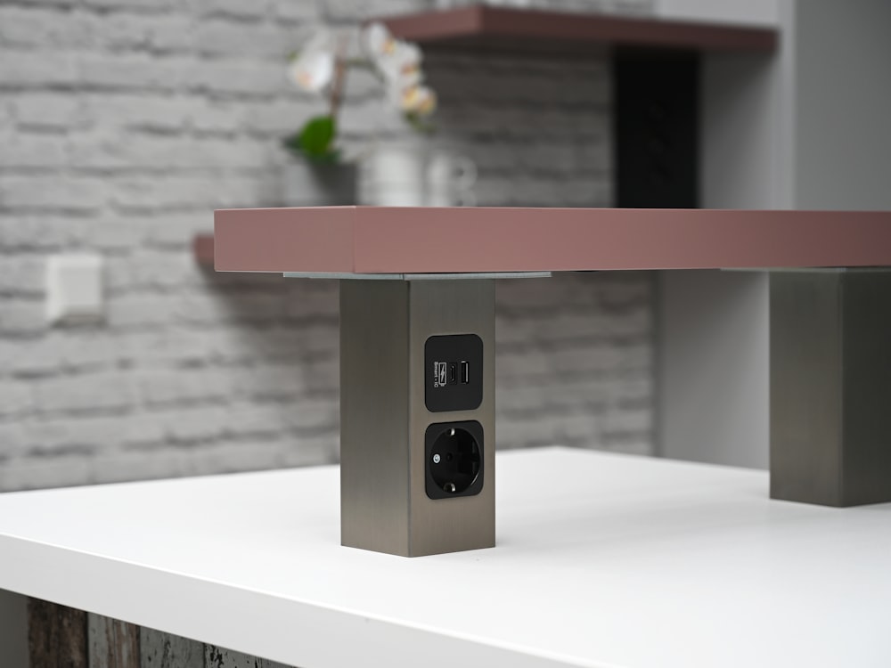 a silver and pink electronic device sitting on top of a white table