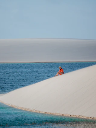a person sitting on top of a sand dune