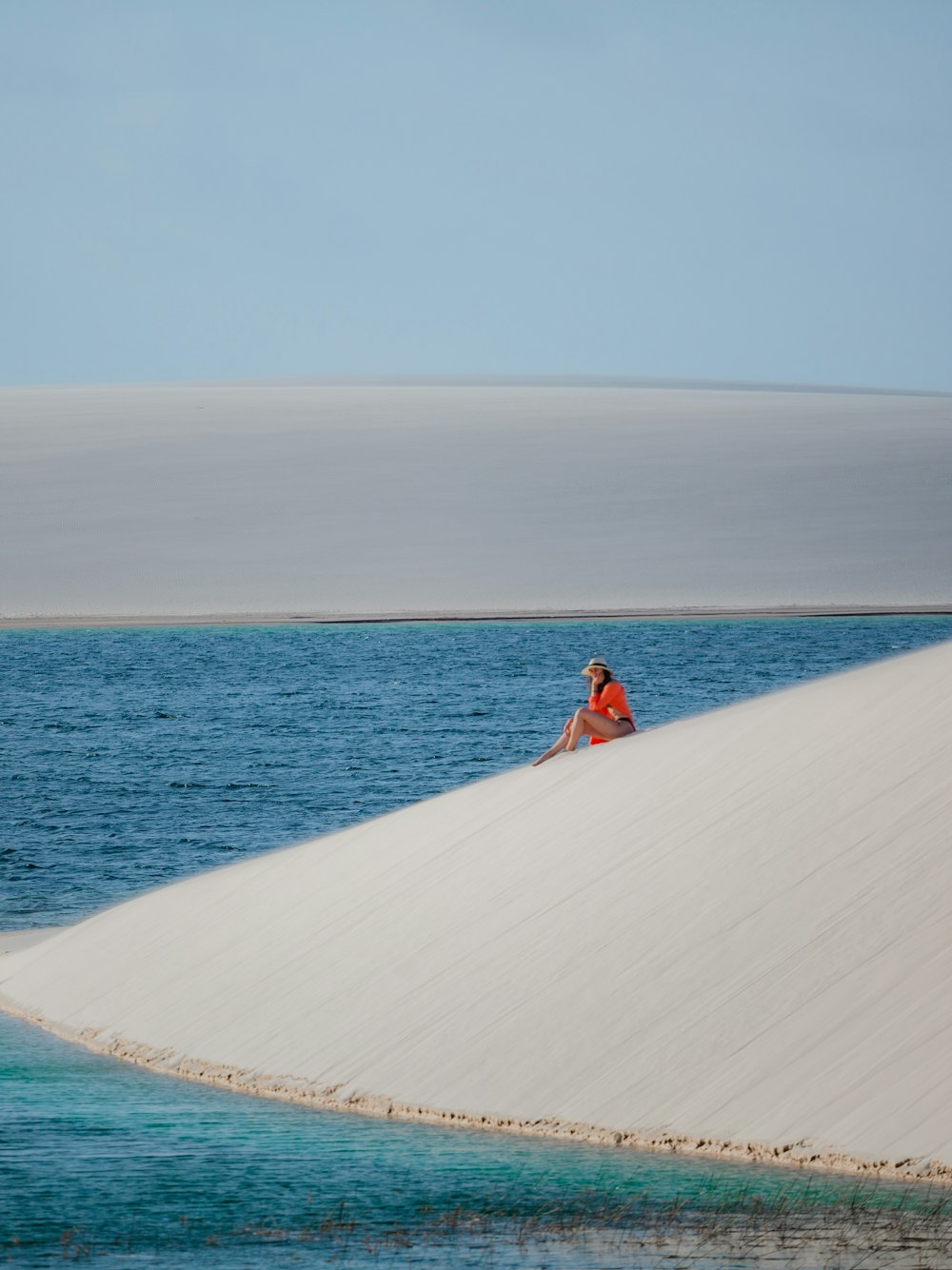 uma pessoa sentada em cima de uma duna de areia