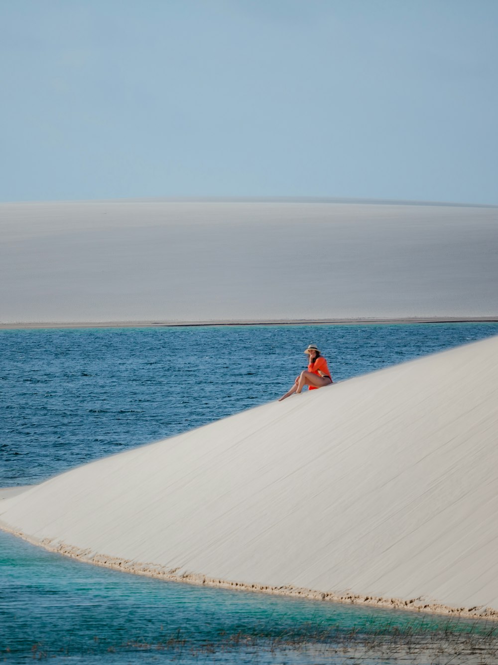 a person sitting on top of a sand dune