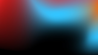 Abstract watercolor effect blending black, white, and subtle red tones representing creative fusion.