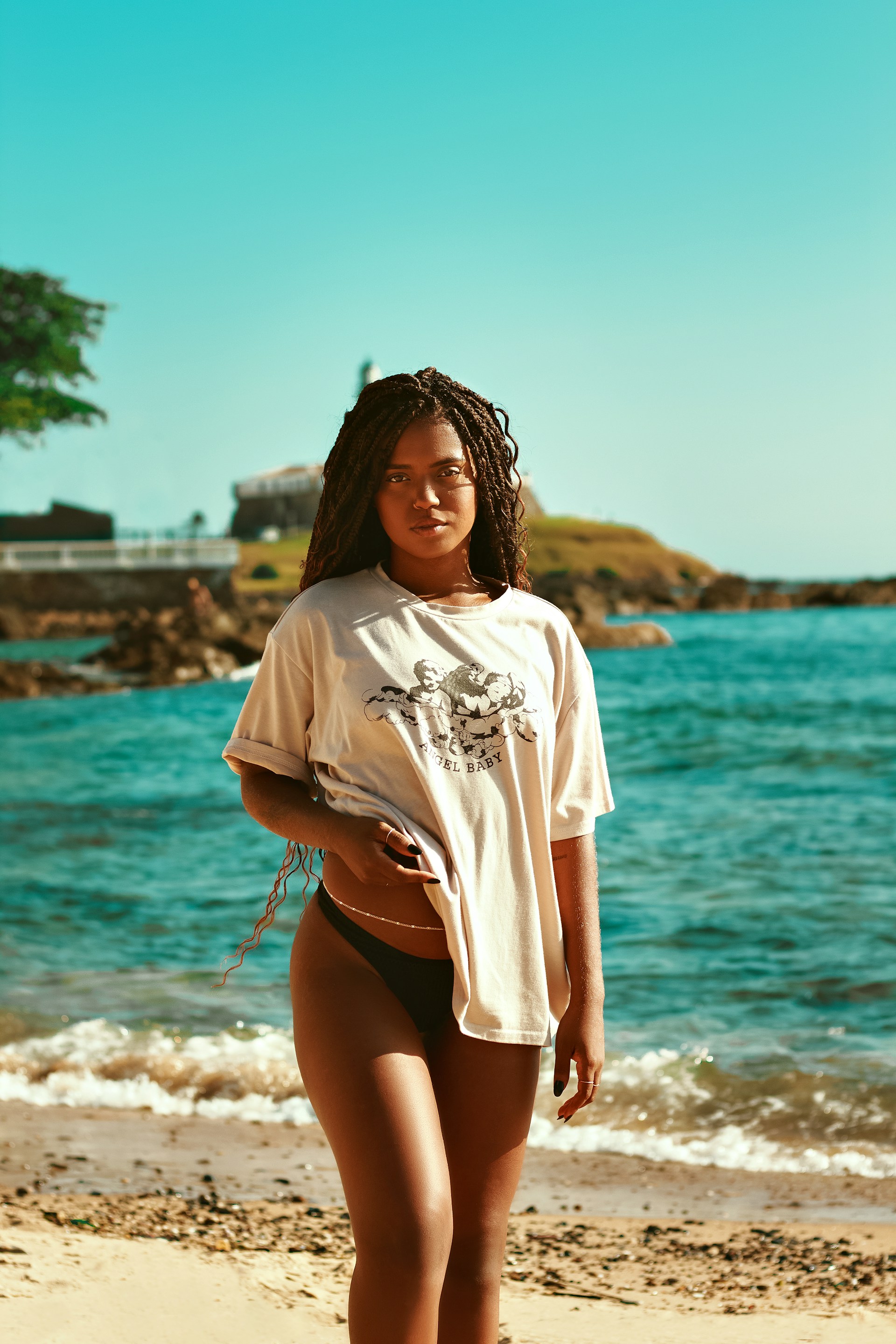 a woman standing on a beach next to the ocean