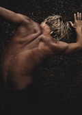 a naked man with no shirt on laying on the ground
