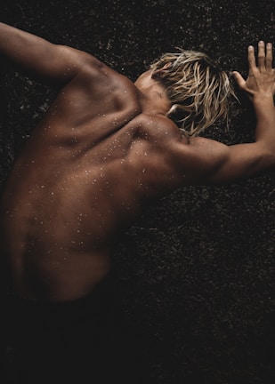 a naked man with no shirt on laying on the ground